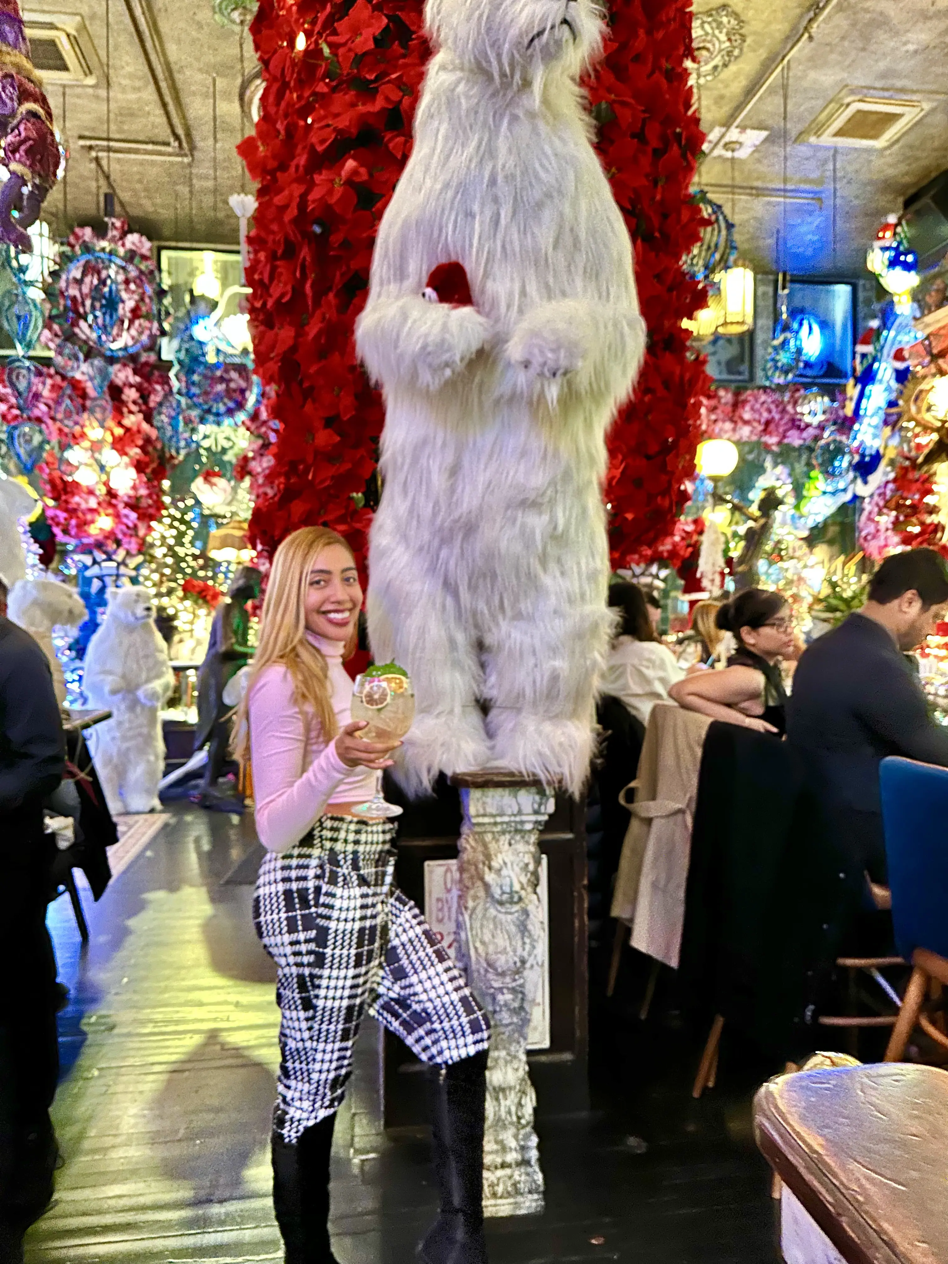 christmas photo with woman wearing pink turtle neck and holiday outfit with christmas decor in background